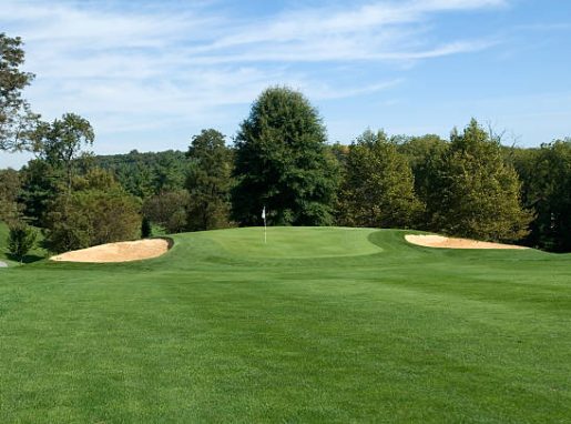 A view of the green from the fairway on a beautiful day.